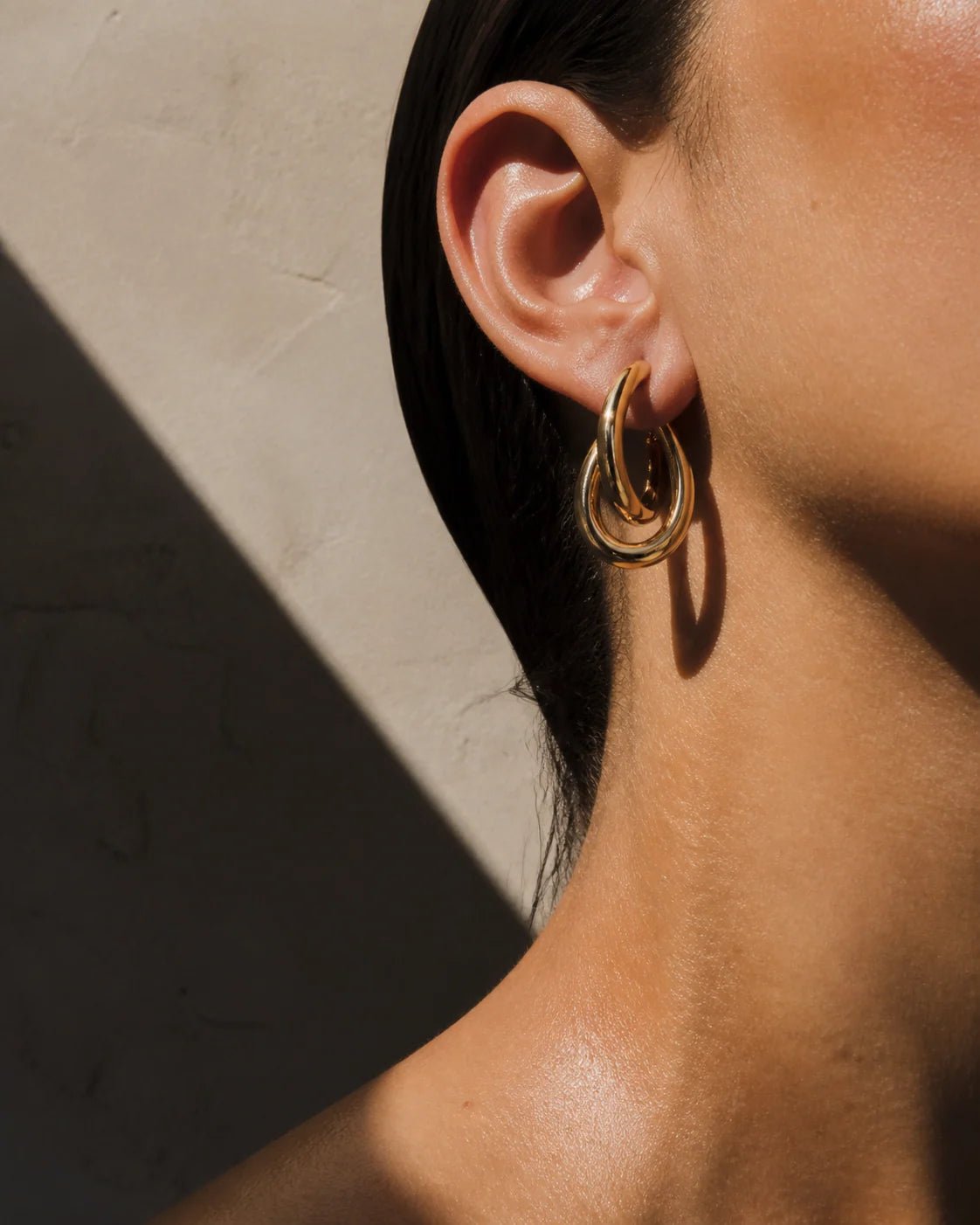 Sculptural gold hoop earring concept worn on ear
